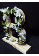 Letra de madera en flores preservadas